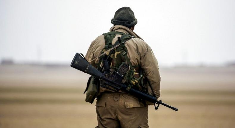 A member of the Syrian Democratic Forces, made up of US-backed Kurdish and Arab fighters, stands guard near the village of Bir Fawaz, in February 2017