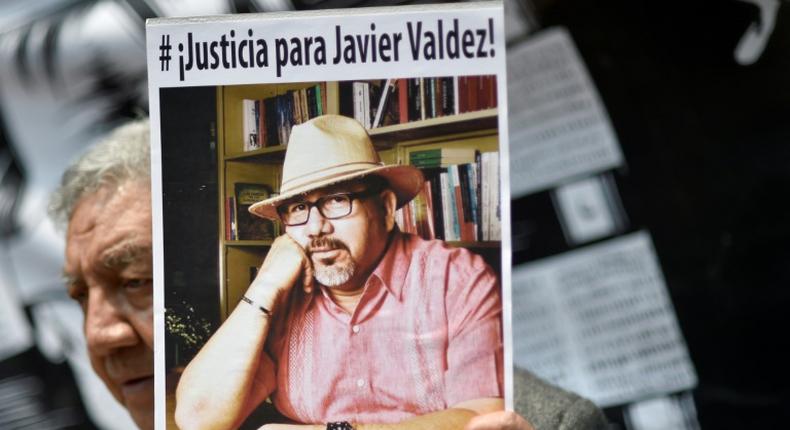 A demonstrator holds a picture of slain Mexican journalist Javier Valdez during a protest in Mexico City on May 16, 2017