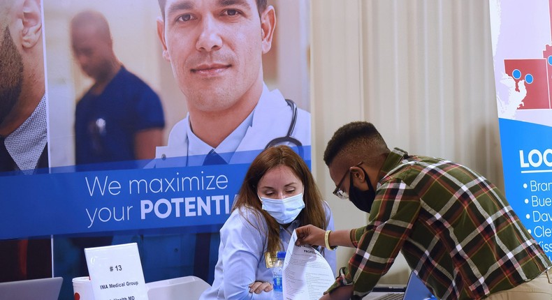 A man hands his resume to an employer at the 25th annual Central Florida Employment Council Job Fair at the Central Florida Fairgrounds.
