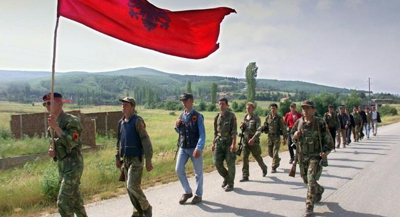 Kosovo Liberation Army (KLA) fighters marching down the mountains towards the Kosovar city of Lapusnik 17 June 1999