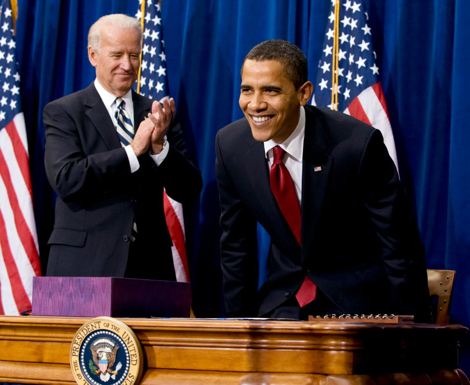 Barack Obama smiles after he signed the American Recovery and Reinvestment Act next to Vice President Joseph Biden.