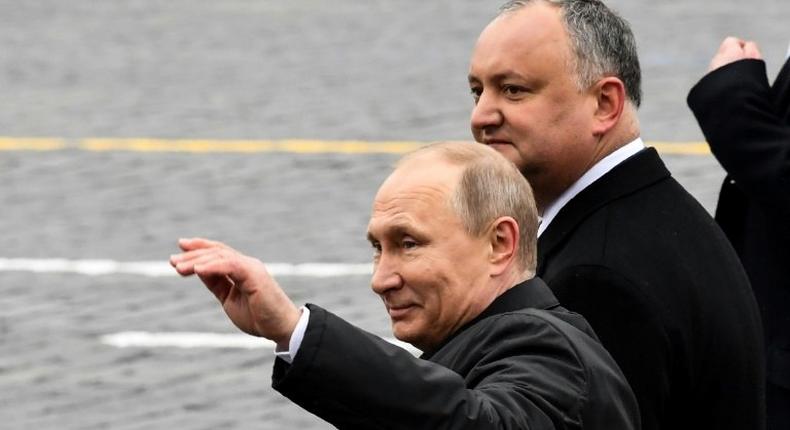 Russian President Vladimir Putin (L) and his Moldovan counterpart Igor Dodon walk on Red Square after the Victory Day military parade in Moscow on May 9, 2017