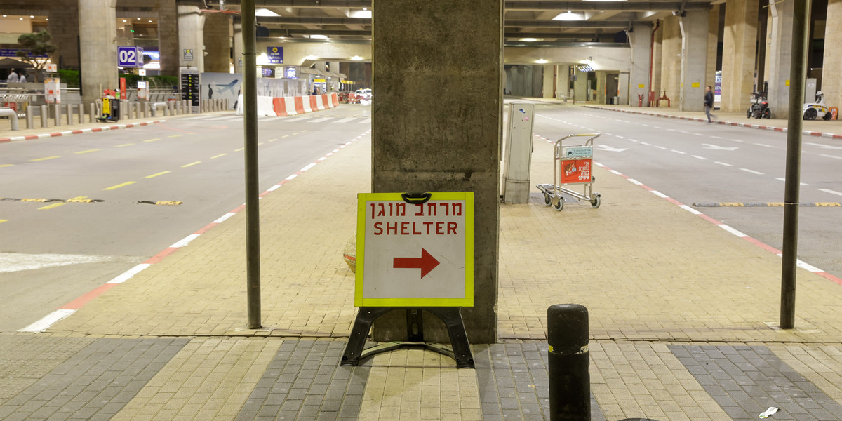 Puste lotnisko w Tel Avivie i znak kierujący do schronu
