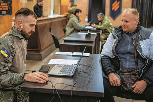 Ochotnik do służby w 3. Samodzielnej Brygadzie Szturmowej Sił Zbrojnych Ukrainy rozmawia z oficerem w obwodzie kijowskim, 9 stycznia 2024 r.