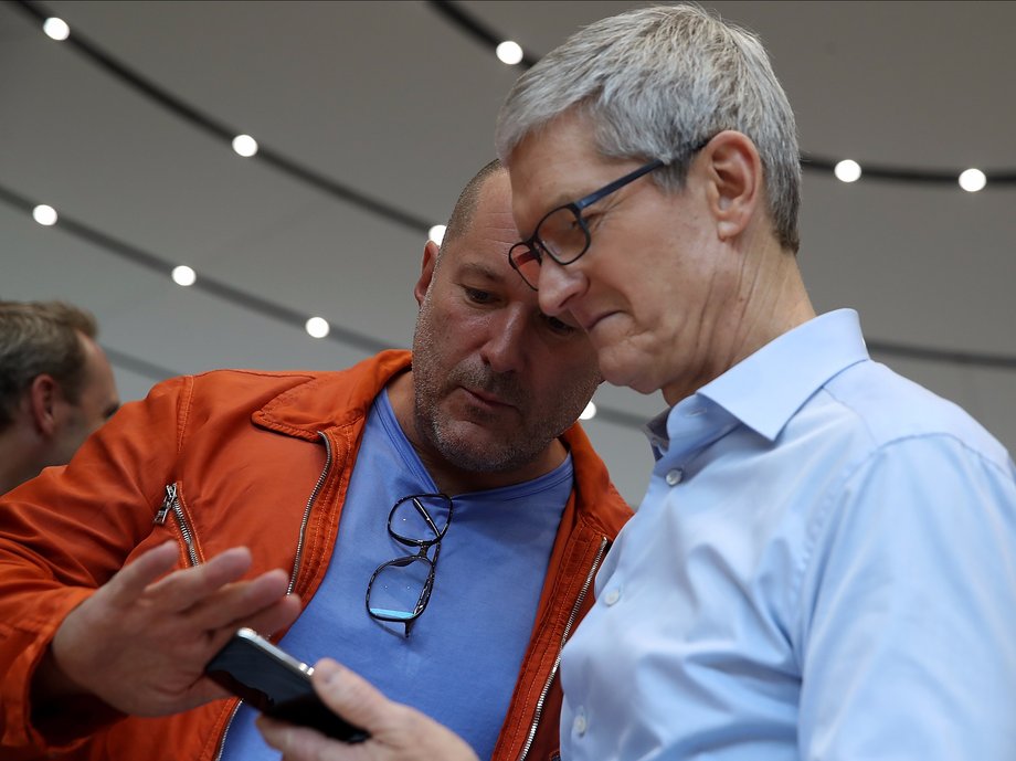 Apple CEO Tim Cook and Ive looking at an iPhone X.