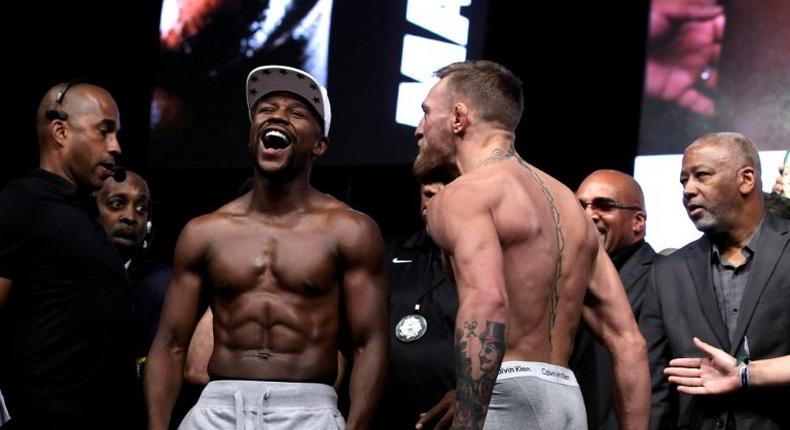 Boxer Floyd Mayweather Jr. (L) and MMA figher Connor Mcgregor pose during their weigh-in in Las Vegas, Nevada