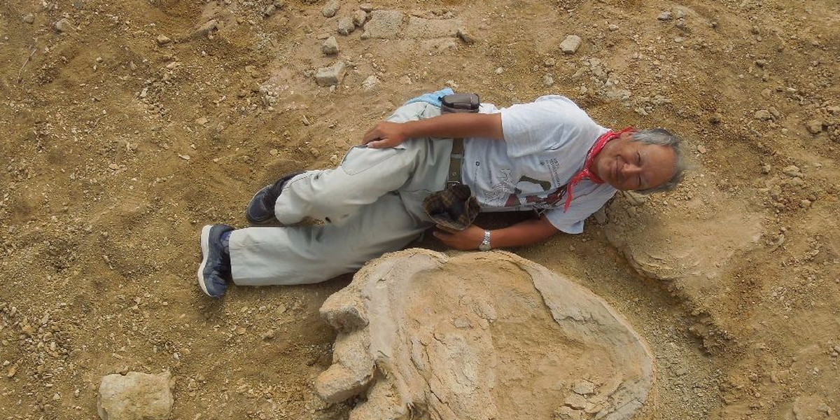Professor Shinobu Ishigaki poses next to the dinosaur footprint in the Gobi Desert.