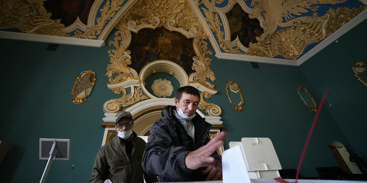 Partia Władimira Putina idzie do wyborów z historycznie niskim, 27-proc. poparciem społecznym. Na zdjęciu mężczyźni oddający swoje głosy w lokalu wyborczym na Dworcu Kazańskim w Moskwie.