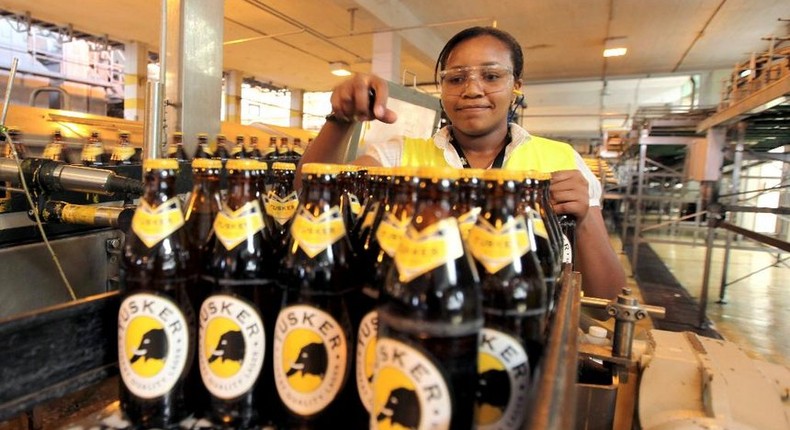 Worker inspecting beer bottles at an EABL plant