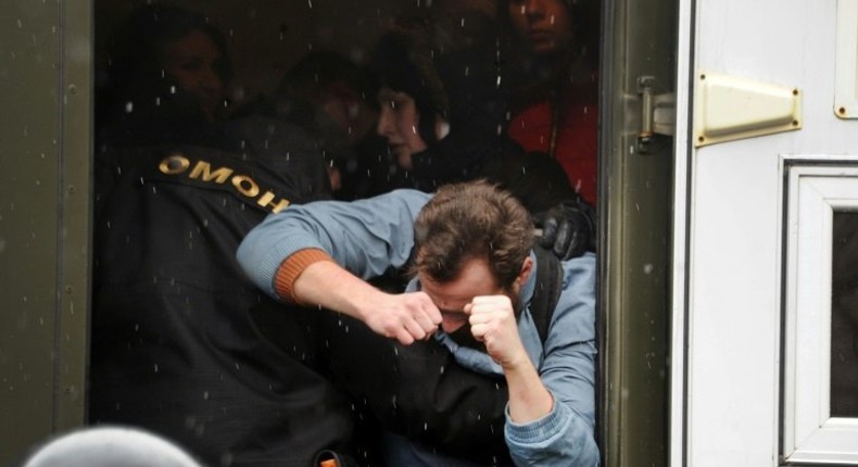 Riot police officers detain participants during a rally against President Alexander Lukashenko's rule and a controversial new tax on spongers - those who work less than six months a year - in Minsk on March 25, 2017