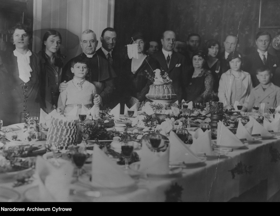 Uczestnicy spotkania Wielkanocnego przy zastawionym świątecznymi potrawami stole, 1931 r.