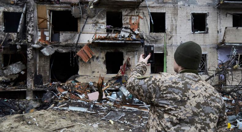 A Ukrainian soldier speaks on his smartphone outside a residential building damaged by a missile on February 25, 2022 in Kyiv, Ukraine.Pierre Crom/Getty Images