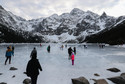 Turyści na tafli lodu na jeziorze Morskie Oko w Tatrach