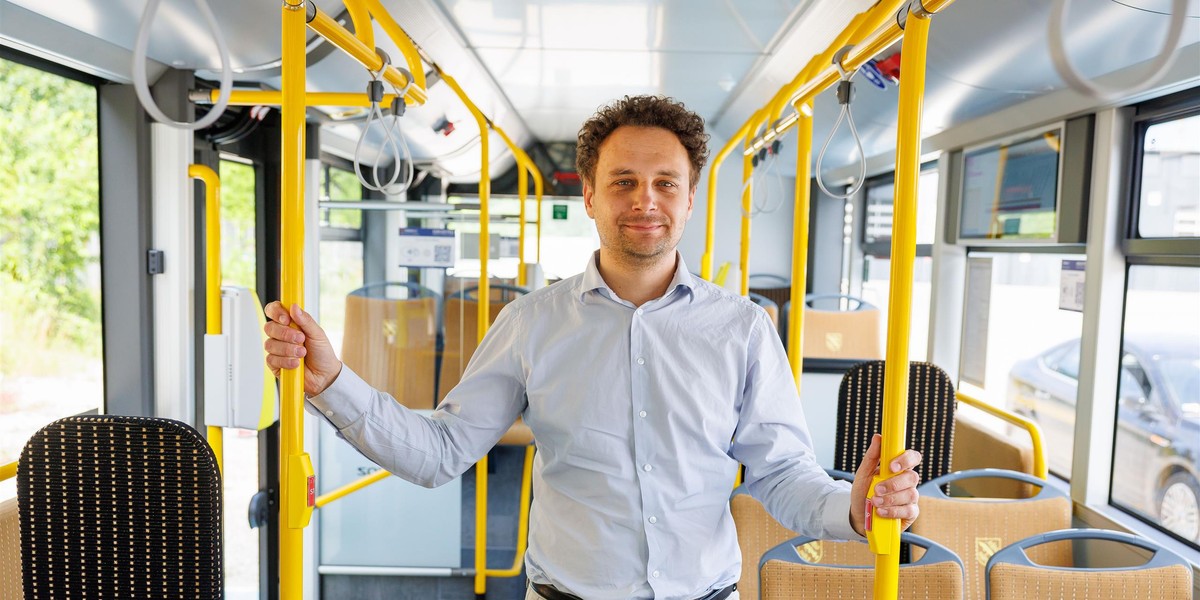 Prezes Komunikacji Miejskiej Rybnik prezentuje jeden z autobusów hybrydowych.