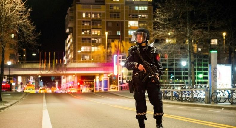 A police officer stands guard near a cordened off area in central Oslo on late April 8, 2017, following the discovery of a 'bomb-like device'