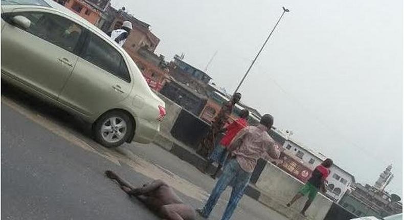 Man strips and lies down in the middle of major road