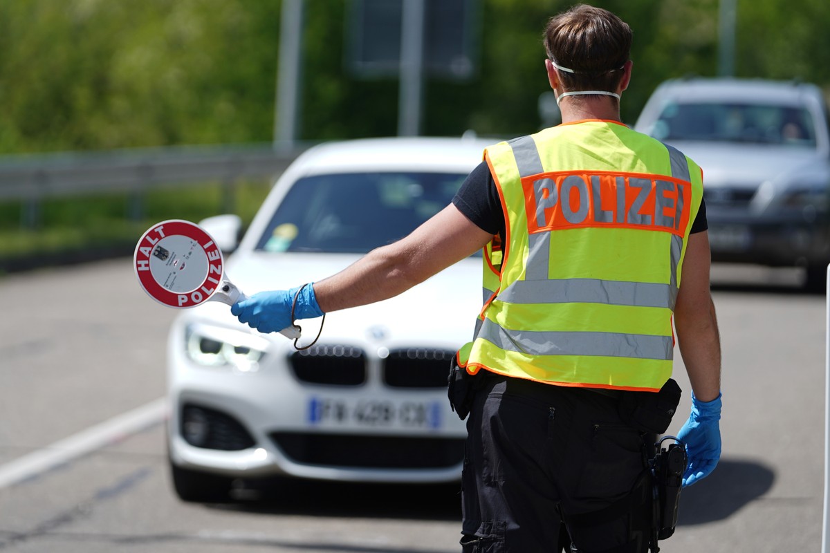 Niemcy przywracają kontrole graniczne na wszystkich swoich granicach lądowych. Niemiecki policjant zatrzymuje samochód do kontroli drogowej