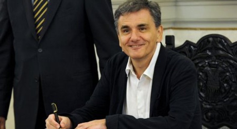 Newly appointed Greek Finance Minister Tsakalotos signs official documents following a swearing-in ceremony at the presidential palace in Athens