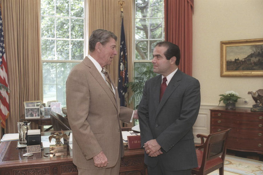 U.S. President Ronald Reagan speaks with Supreme Court Justice nominee Antonin Scalia in the White House Oval Office in Washington, DC in a July 7, 1986.