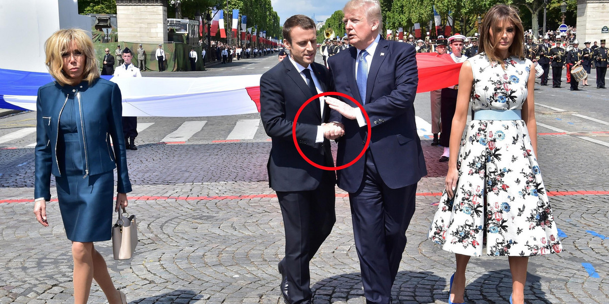 French President Macron shakes hands with US President Trump next to Macron's wife Brigitte Macron and US First Lady Melania Trump during the traditional Bastille Day military parade in Paris