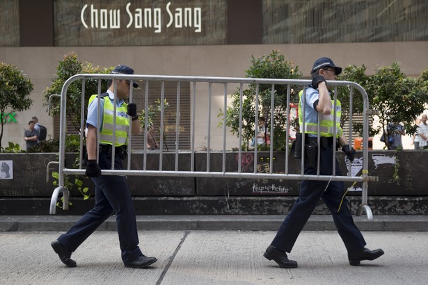 Protesty w Hongkongu. Policjanci przenoszą barykady obok sklepu jubilerskiego Chow Sang Sang Holdings International Ltd. na Nathan Road w dzielnicy Mong Kok w Hong Kongu.