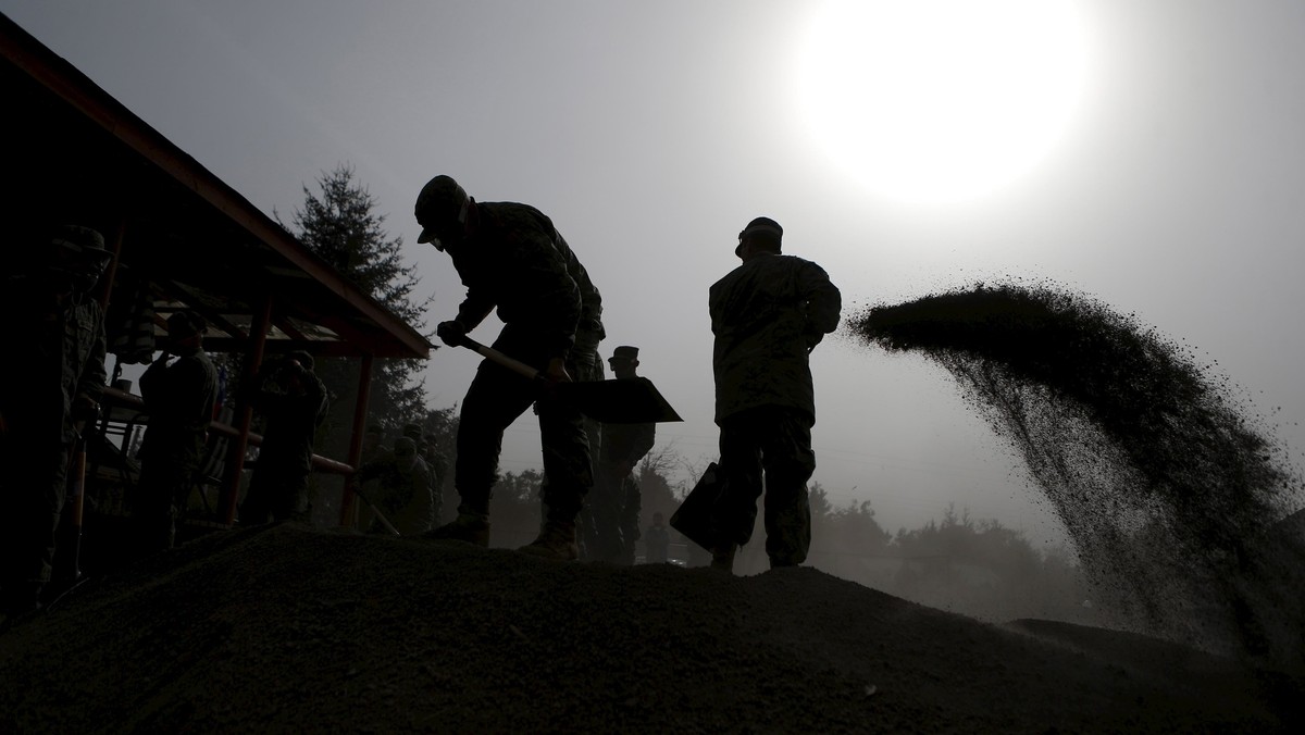 Soldiers remove ashes from a house nearby Ensenada which is covered with ashes from Calbuco Volcano