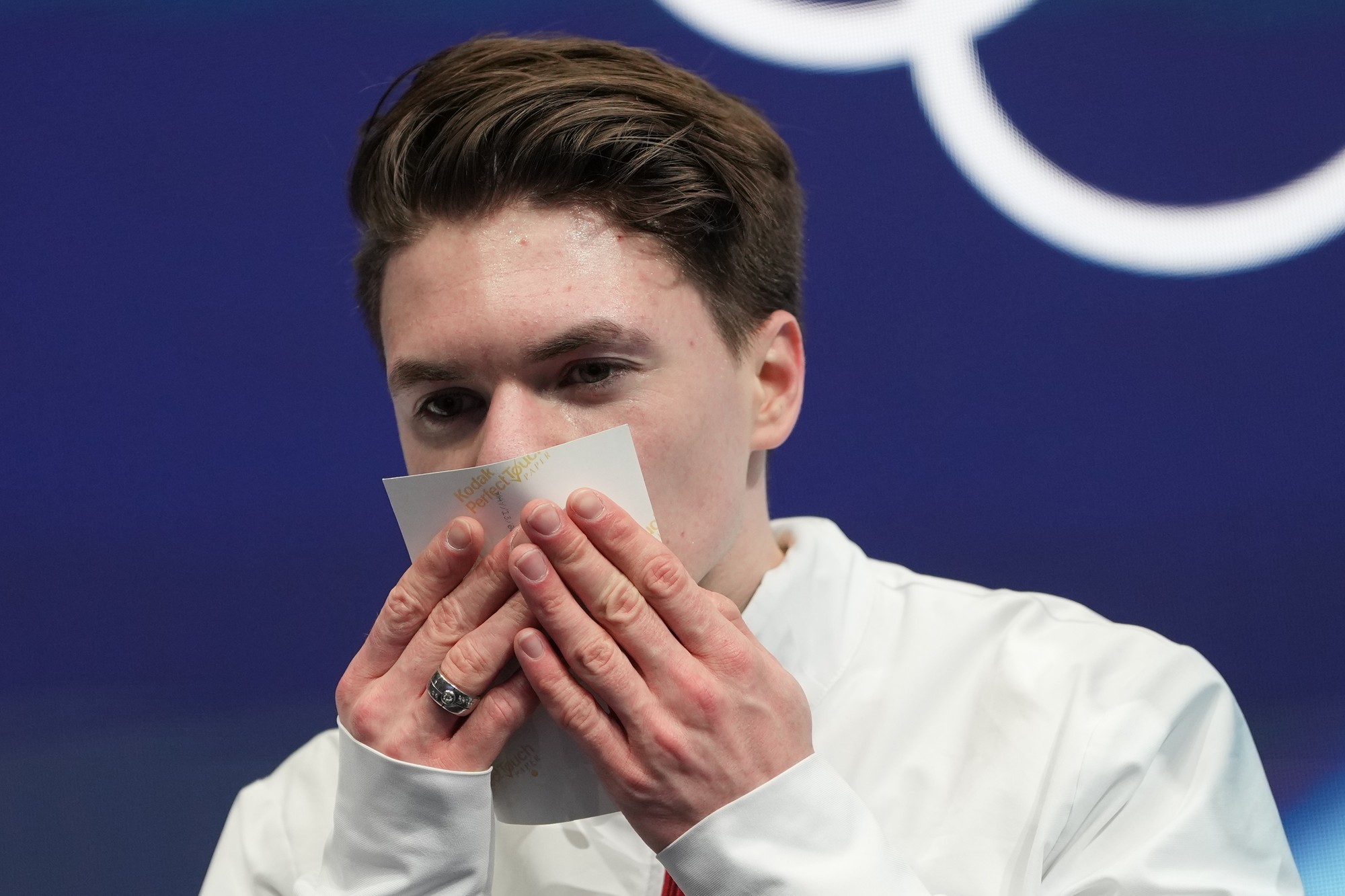 Maxim Naumov drží fotografiu svojich rodičov po svojej voľnej jazde na XXV. zimných olympijských hrách v Miláne v piatok 13. februára 2026. 