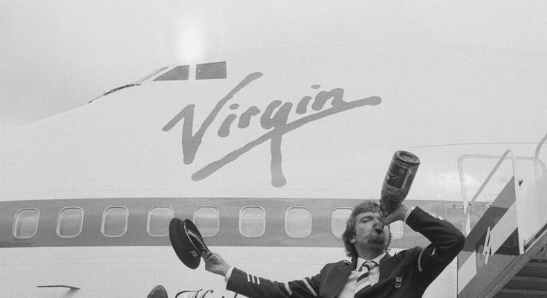 Sir Richard Branson, pictured on air stairs drinking from a bottle of champagne ahead of the inaugural flight of Virgin Atlantic Airways in 1984.Terry Disney/Getty Images