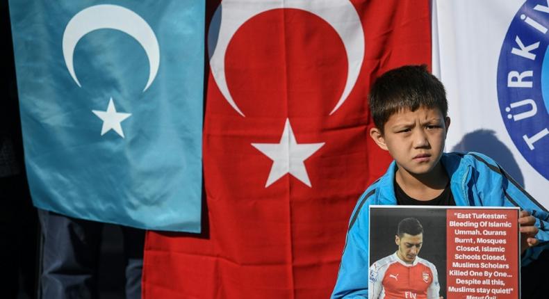 A supporter of China's Muslim Uighur minority holds a placard of Arsenal's Turkish-origin German midfielder Mesut Ozil during a demonstration at Beyazid square in Istanbul