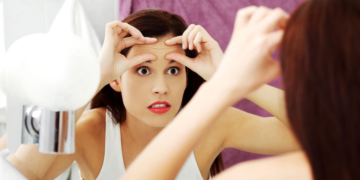 Young woman checking her wrinkles