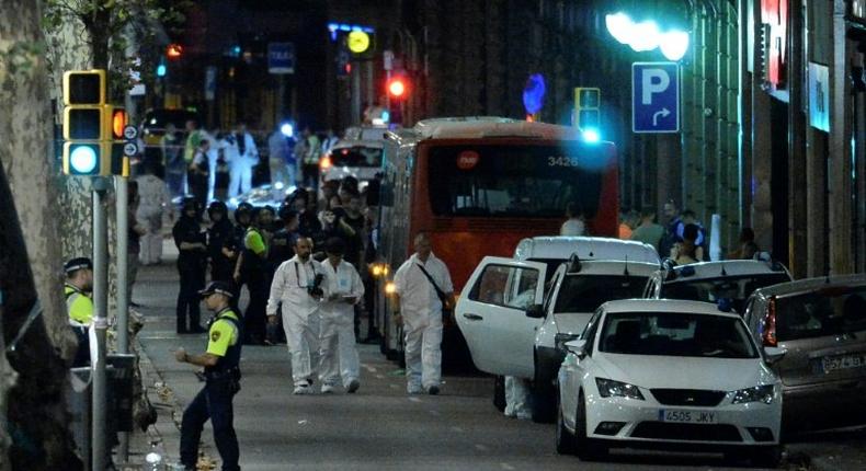 Forensic policemen arrive in the cordoned off area on Las Ramblas in Barcelona on August 17, 2017 after a van ploughed into the crowd, killing 13 people and injuring over 80