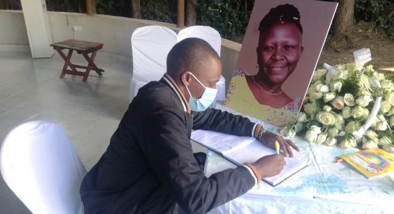 A mourner signs the condolence book for the late Jennifer Wambua