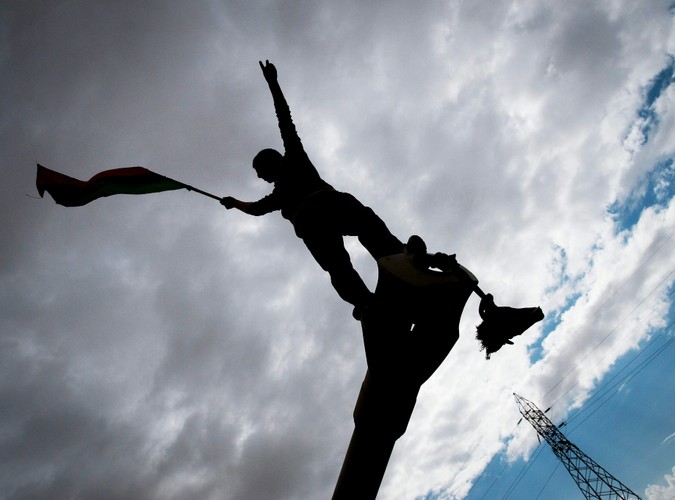 Rebeliant na spalonym czołgu, należącym do sił Muammara Kadafiego, zniszczonym podczas francuskiego nalotu 25 km od Bengazi