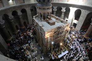 Christian worshippers surround the Edicule as they take part in a Sunday Easter mass procession in t