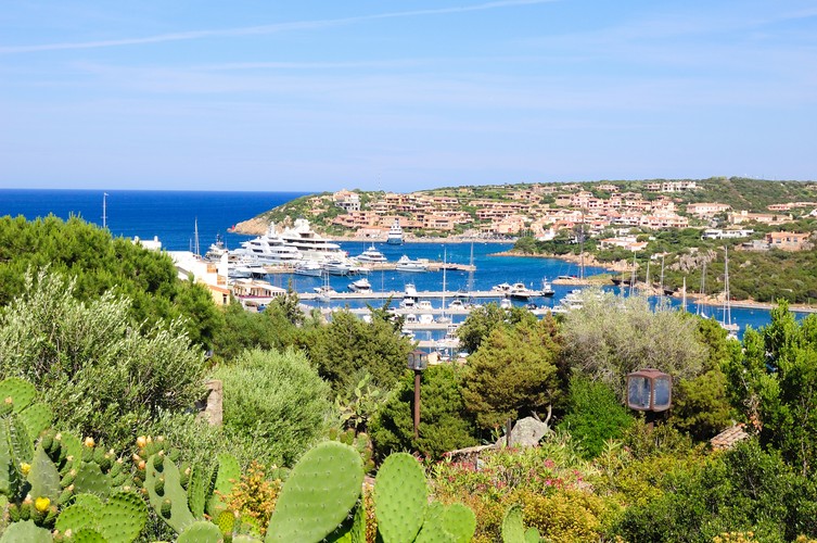 <strong>Porto Cervo – synonim luksusowych wakacji</strong>
<br></br>
Szmaragdowe Wybrzeże to miejsce w którym znajdziemy najpiękniejsze na świecie plaże o białym piasku, położone pośród krystalicznie czystych zatoczek mieniących się we wszystkich odcieniach błękitu. Symbolem Szmaragdowego wybrzeża jest zaś Porto Cervo. Podczas podróży na Sardynię, warto zarezerwować sobie chociażby jeden dzień, by zobaczyć to niepowtarzalne miasto. 
<br></br>
Z luksusową turystyką kojarzy się ono nie bez powodu. Porto Cervo powstało bowiem z inicjatywy księcia Karim Aga Khan, brytyjskiego milionera i jednego z najbogatszych osób na świecie. To on w latach pięćdziesiątych zlecił zaaranżowanie ekskluzywnej, wręcz utopijnej przestrzeni, kwintesencji śródziemnomorskiego luzu, raju tylko dla wybranych. W rezultacie powstały tu wspaniałe posiadłości, zaprojektowane przez najsłynniejszy architektów, m.in. Jacquesa Couelle czy Luigi Viettiego. Przepych otoczony naturalną scenerią najpiękniejszej części wyspy.   
Jak przystało na Szmaragdowe Wybrzeże, główną atrakcją są tu oczywiście plaże. Jedną z najbardziej popularnych jest Cala Granu, leżąca niespełna kilometr od kurortu. Ma zaledwie około 100 metrów długości, ale urok tego miejsca wynagradza wszystko. Nieco dalej, około 3 kilometrów od Porto Cervo znajduje się kolejna wyjątkowa plaża – Spiaggia del Pevero z której roztacza się wspaniały widok na pobliską wyspę Nibani. Warto też wybrać się na wyspy archipelagu La Maddalena, słynące z różowego piasku.
<br></br>
Porto Cervo to jednak nie tylko plaże. Nie zapominajmy, że północna część wyspy skrywa wiele śladów starożytnych cywilizacji. Najbardziej tajemniczą z nich jest cywilizacja nuorska, której pozostałością są nuragi – okrągłe, kamienne grobowce, które do dzisiaj spędzają sen z oczu archeologów. Nieopodal Porto Cervo można zobaczyć najbardziej monumentalne z nich – Tombe dei giganti – w których znaleziono 2,5 metrowe szkielety! Ich tajemnicy wciąż nie udało się wyjaśnić.
<br></br>
Źródło: r.pl/wlochy/sardynia