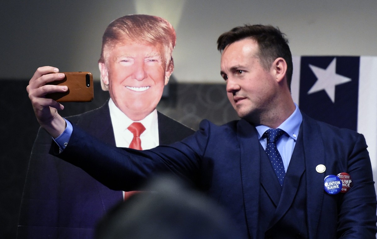 Wybory prezydenckie w USA. Mężczyzna robi sobie zdjęcie z fotografią Donalda Trumpa