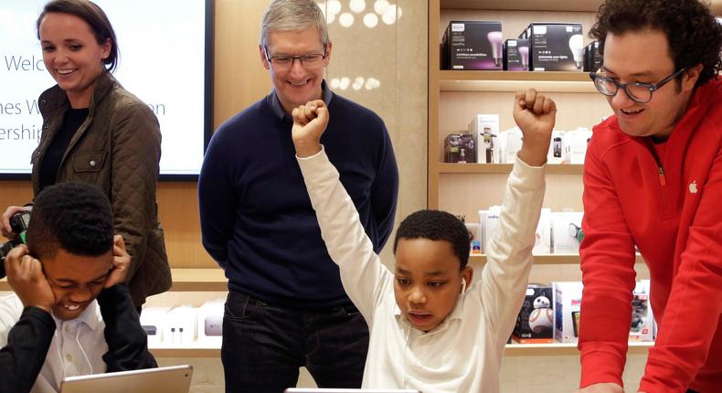 Jaysean Erby, middle right, solving a coding problem as Apple CEO Tim Cook watches at an Apple Store in 2015.