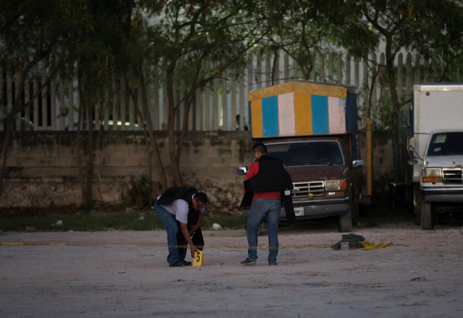 Police officers work at a crime scene after an armed group of men driving past on motorcycles shot at the attorney general's office, according to local media, in Cancun, Mexico, January 17, 2017.