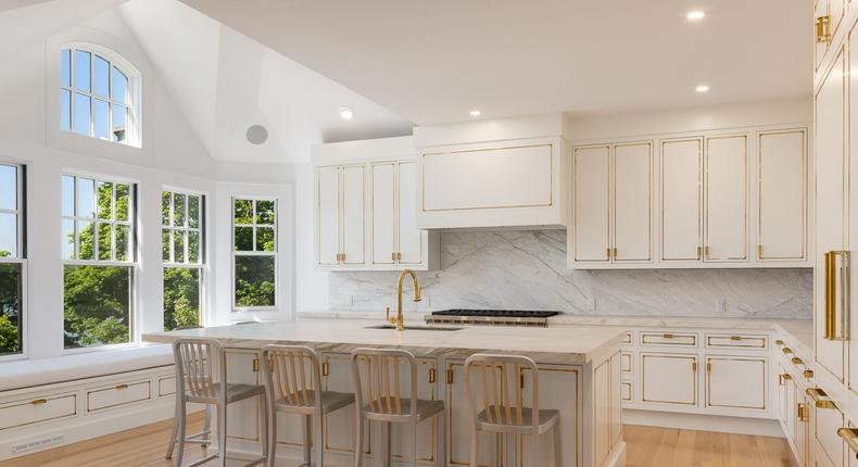 A white and gold-accented kitchen.Daniel Milstein Photography