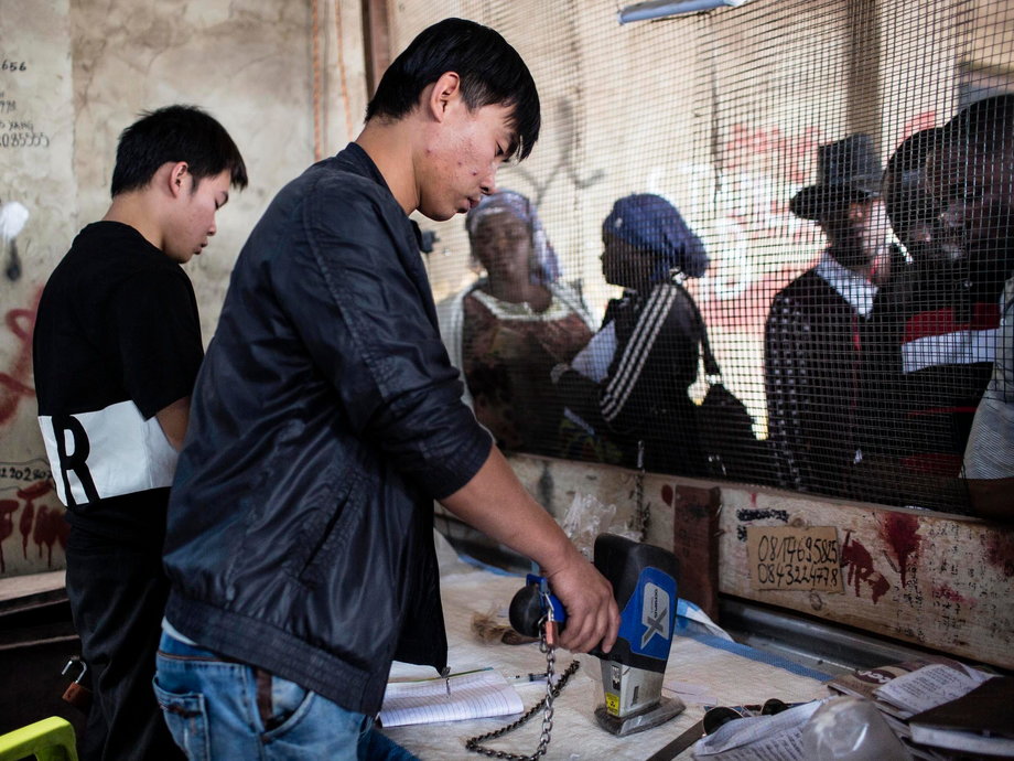 Xu Bin Liu testuje czystość kobaltu, który kupuje na rynku Musompo na obrzeżach Kolwezi.  