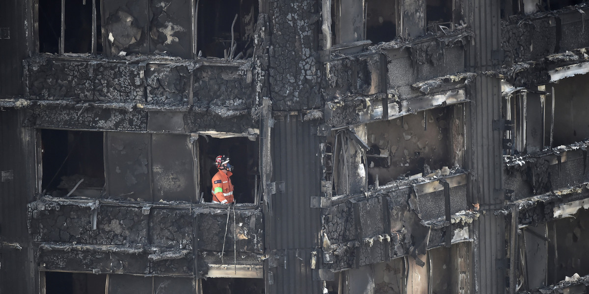 An investigator searches a burnt-out Grenfell apartment.