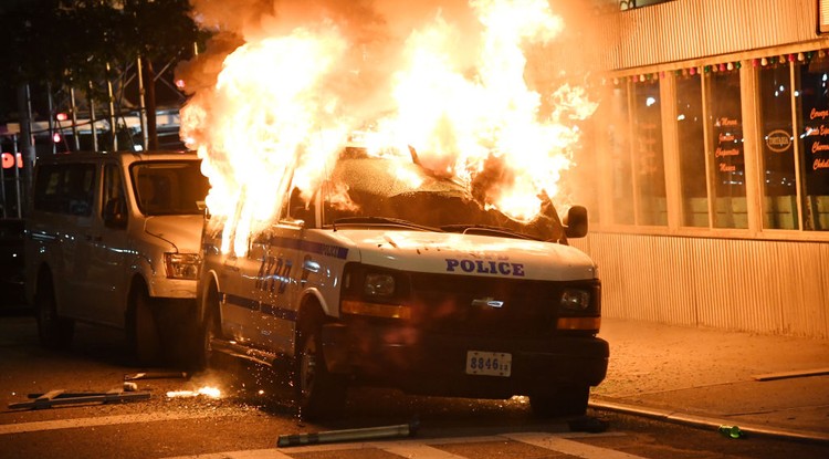 Égő rendőrautó New York utcáján, május 30-án.