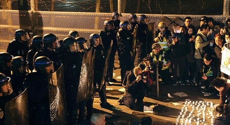 Police face demonstrators during a protest in front of the police headquarters in the 19th arrondissement of Paris on