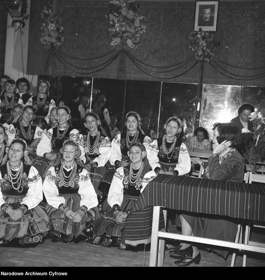 Chór w strojach łowickich podczas próby śpiewu, 1. z prawej siedzi Mira Zimińska-Sygietyńska.