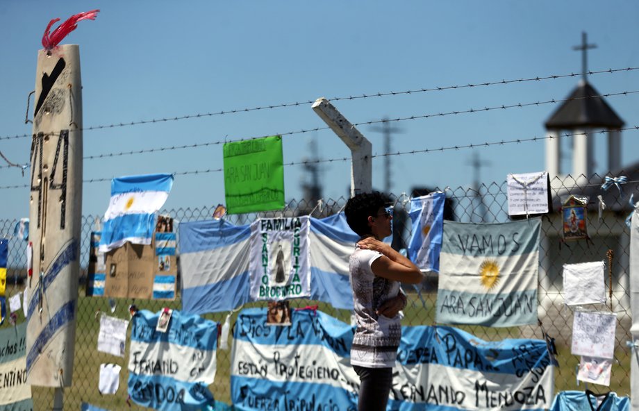 A woman looks at messages and signs supporting the 44 crew members of the missing submarine on a fence at an Argentine naval base in Mar del Plata on November 22.