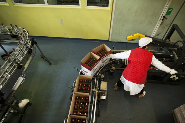Pracownicy pakują butelki wódki do kartonów w fabryce wódek Sobieski w Starogardzie Gdańskim