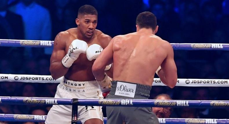 Britain's Anthony Joshua (L) looks for an opening against Ukraine's Wladimir Klitschko during the third round of their IBF, IBO and WBA, world heavyweight title fight, at Wembley Stadium in London, on April 29, 2017