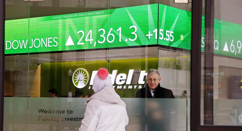 FILE - In this Feb. 6, 2018, file photo, a woman walks through the front doors at a Fidelity Investments office on Congress Street as the ticker displays stock market numbers in Boston. Federal regulators are moving to require that brokers provide their customers with detailed disclosures of their potential conflicts of interest when dispensing advice for retirement planning and other investments. (AP Photo/Stephan Savoia, File)