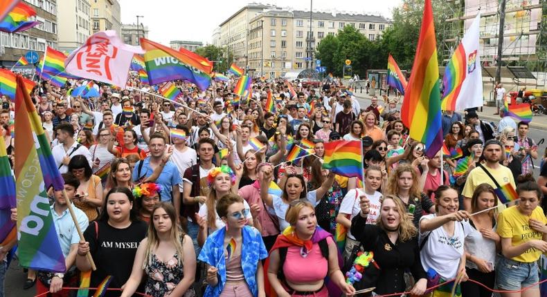 People wave rainbow flags during the Baltic gay pride parade on June 8, 2019 on the streets of the Polish capital Warsaw