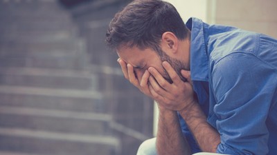 stressed sad crying man sitting outside